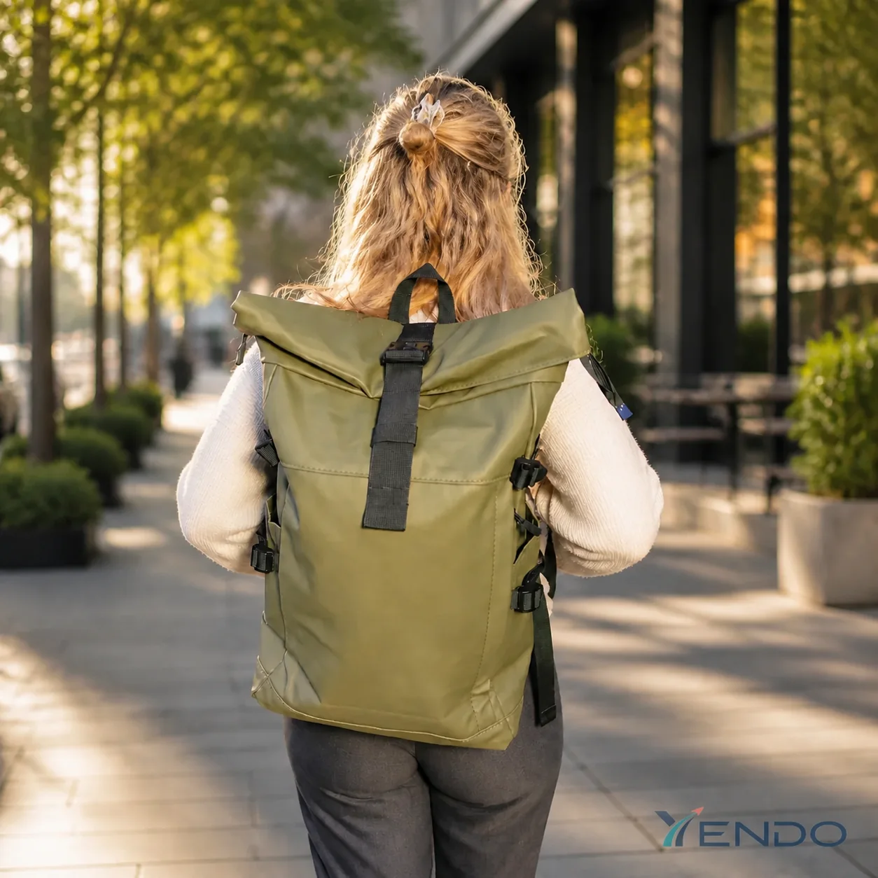 Mochila YENDO Trayecto verde oliva usada por mujer en entorno urbano